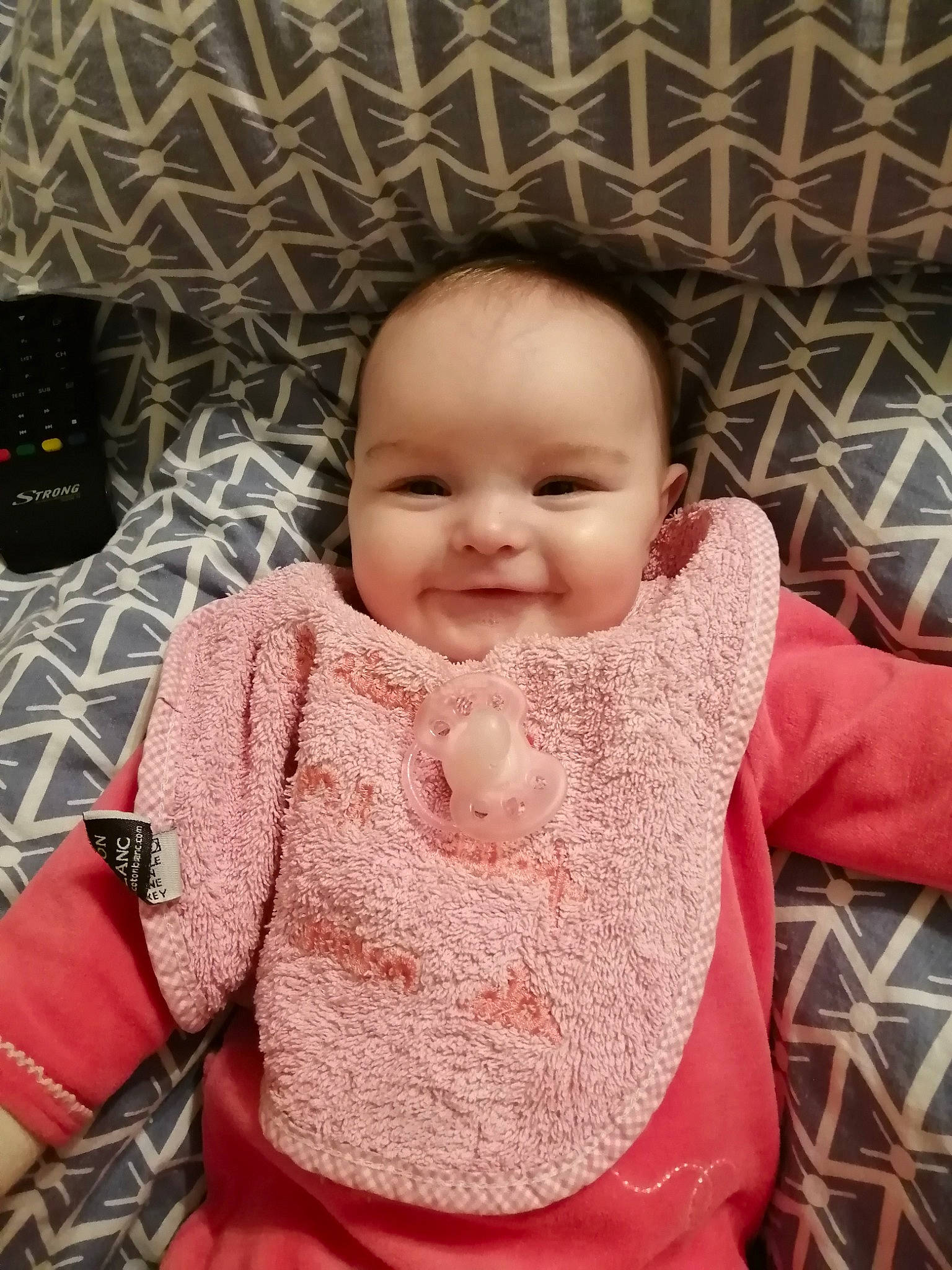 Chloé participe au concours pour gagner de l'argent avec cette photo : baby, baby_toddler_clothing, cheek, chin, eye, facial_expression, hairstyle, happy, head, iris, joy, lip, nose, person, pink, product, skin, sleeve, smile, standing