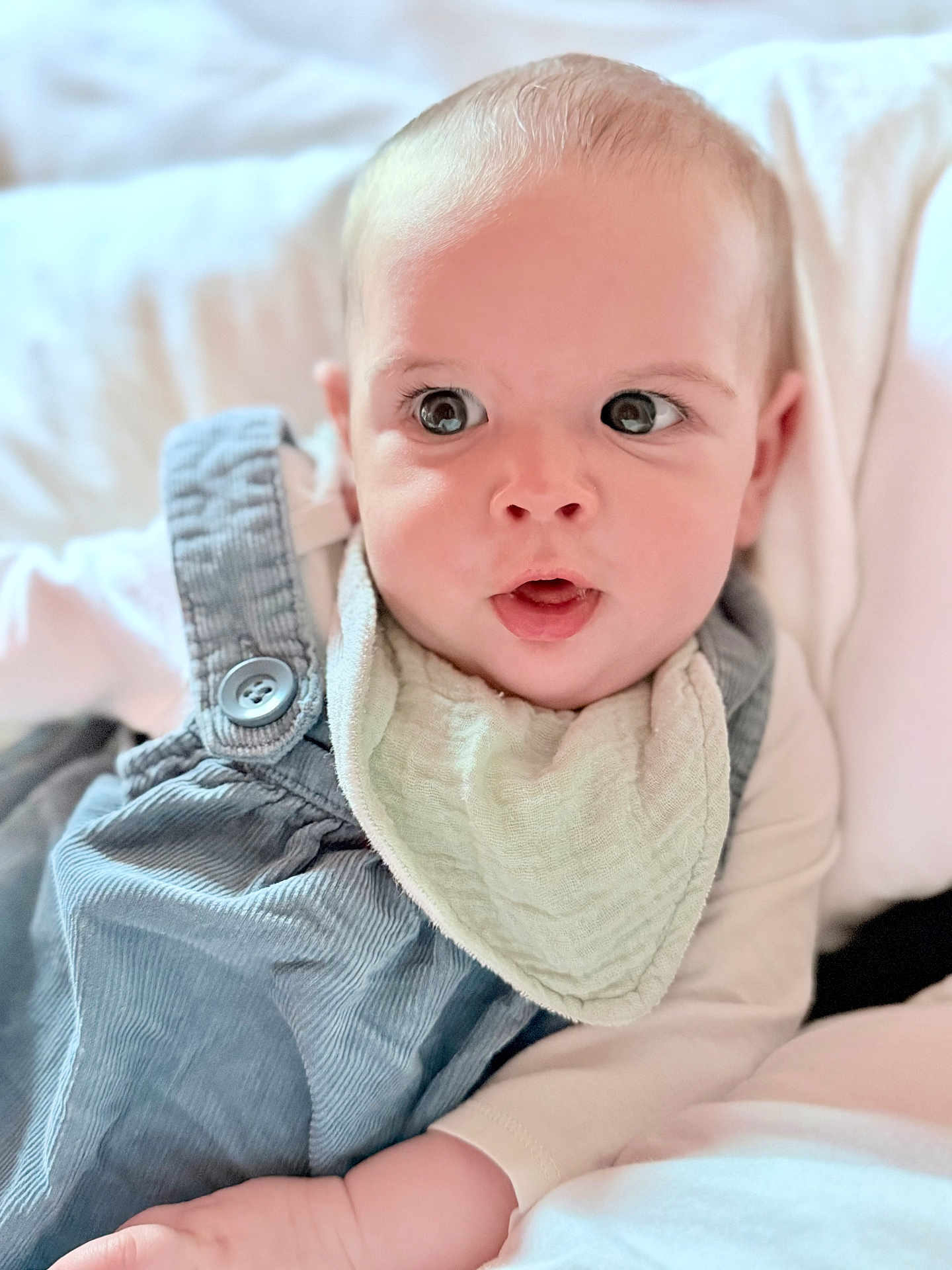 Olivia participe au concours pour gagner de l'argent avec cette photo : baby, infant, face, eyes, overalls, bib, clothing, expression, curious, portrait, child, skin, hand, white_shirt, soft, lying_down, indoors, cute, young, person