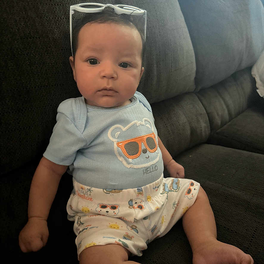 Leo joined the competition — help win amazing prizes! accessories, architecture, baby, bodypart, building, clothing, couch, cushion, face, finger, furniture, glasses, hand, head, homedecor, person, photography, portrait, shorts, sitting