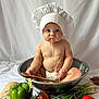 baby, chef_hat, spaghetti, mixing_bowl, diaper, green_bell_pepper, red_bell_pepper, tomatoes, green_onions, onion, bread, wooden_spoon, food, kitchen, cute, child, sitting, playful, white_background, healthy_food