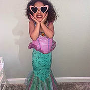 Aria joined the competition — help win amazing prizes! child, girl, mermaid_costume, dress, pink, green, heart_shaped_sunglasses, smiling, posing, indoor, carpet, wall, curly_hair, playful, costume, fashion, fun, cute, portrait, happy