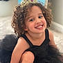 Aria is registered to the contest to win money with this photo: child, smiling, curly_hair, black_dress, tutu, tiara, princess, indoors, carpet, happy, portrait, cute, young_child, girl, playful, costume, headwear, fashion, person, sitting