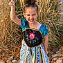 autumn, child, colorful, cute, dress, fashion, girl, grass, happy, joyful, nature, outdoor, person, pointing, portrait, princess_dress, rocks, smiling, standing, young