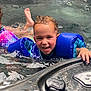 child, water, swimming, pool, hot_tub, floatation_device, blue, smiling, wet_hair, splashing, hand, face, playful, summer, outdoor, fun, kid, safety, joy, recreation