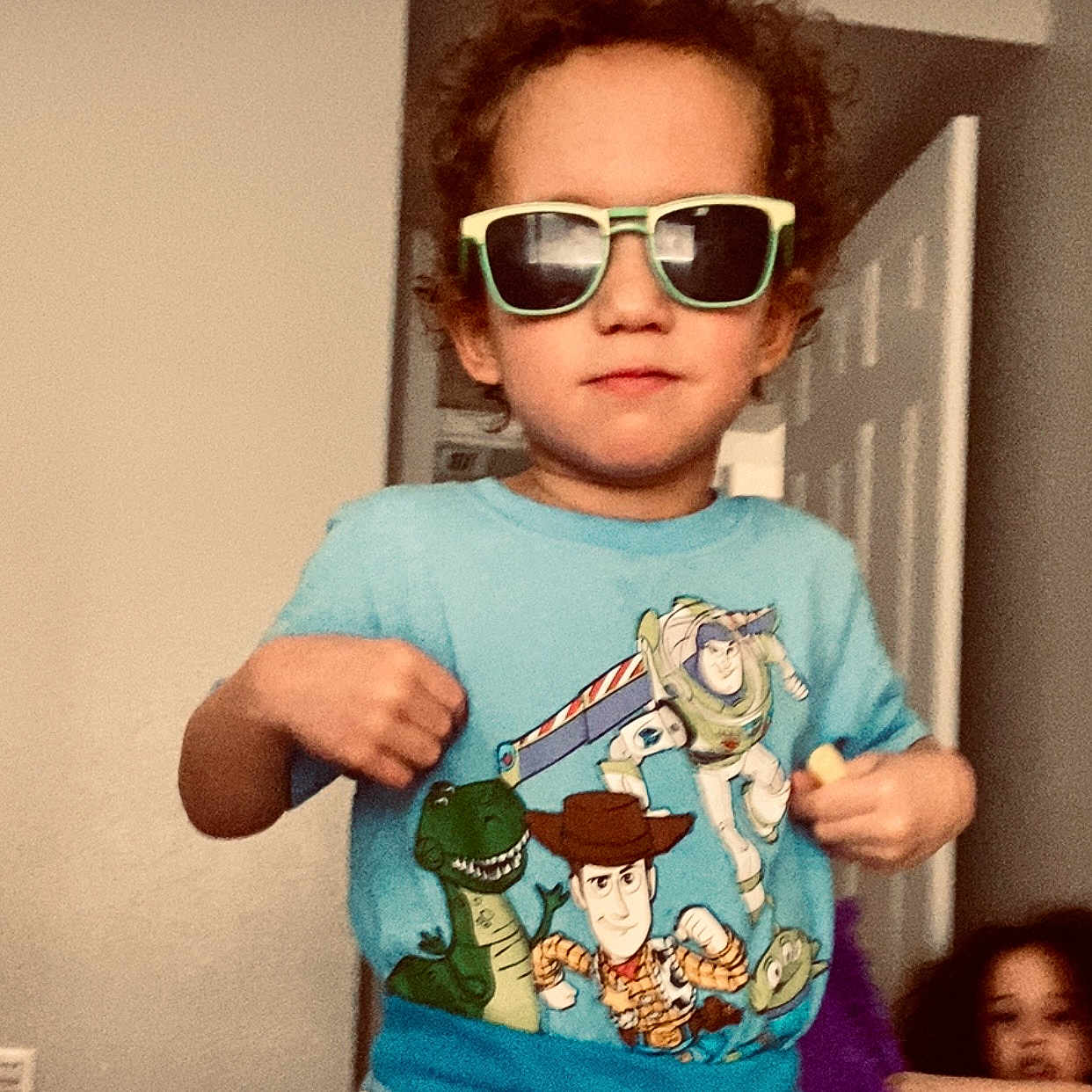 Elijah joined the competition — help win amazing prizes! child, boy, sunglasses, toy_story, blue_shirt, indoor, curly_hair, posing, playful, toddler, clothing, person, room, door, background, young_child, casual, smiling, fun, kids