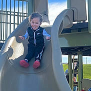 Elijah joined the competition — help win amazing prizes! child, toddler, slide, playground, outdoor, smiling, curly_hair, nike, jacket, pants, red_shoes, blue_sky, grass, daylight, fun, playing, happy, person, leisure, recreation
