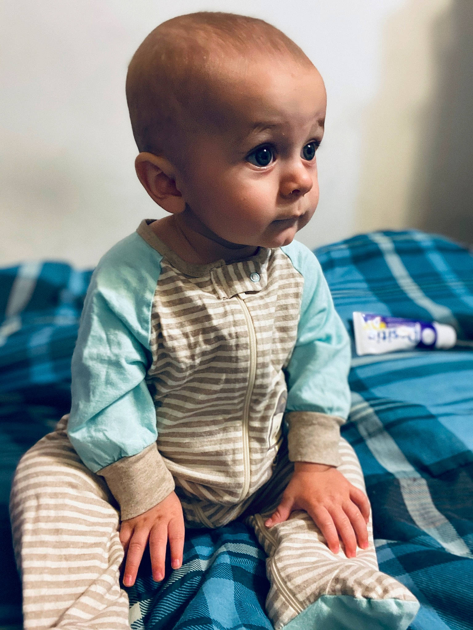 Axton is registered to the contest to win money with this photo: adaptation, baby, blue, cheek, child, eye, face, head, human, nose, pattern, person, plaid, sitting, skin, sleeve, smile, toddler