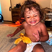 Aaliyah is registered to the contest to win money with this photo: animal, baby, carpet, child, cute, diaper, duckling, expression, face, furniture, happy, home, indoor, pet, playing, sitting, smile, toddler, yellow_duck, young_child