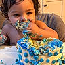 birthday, blue_frosting, cake, celebration, chair, child, curly_hair, dessert, eating, face, food, frosting, hands, indoors, messy, portrait, smiling, table, toddler, yellow_frosting