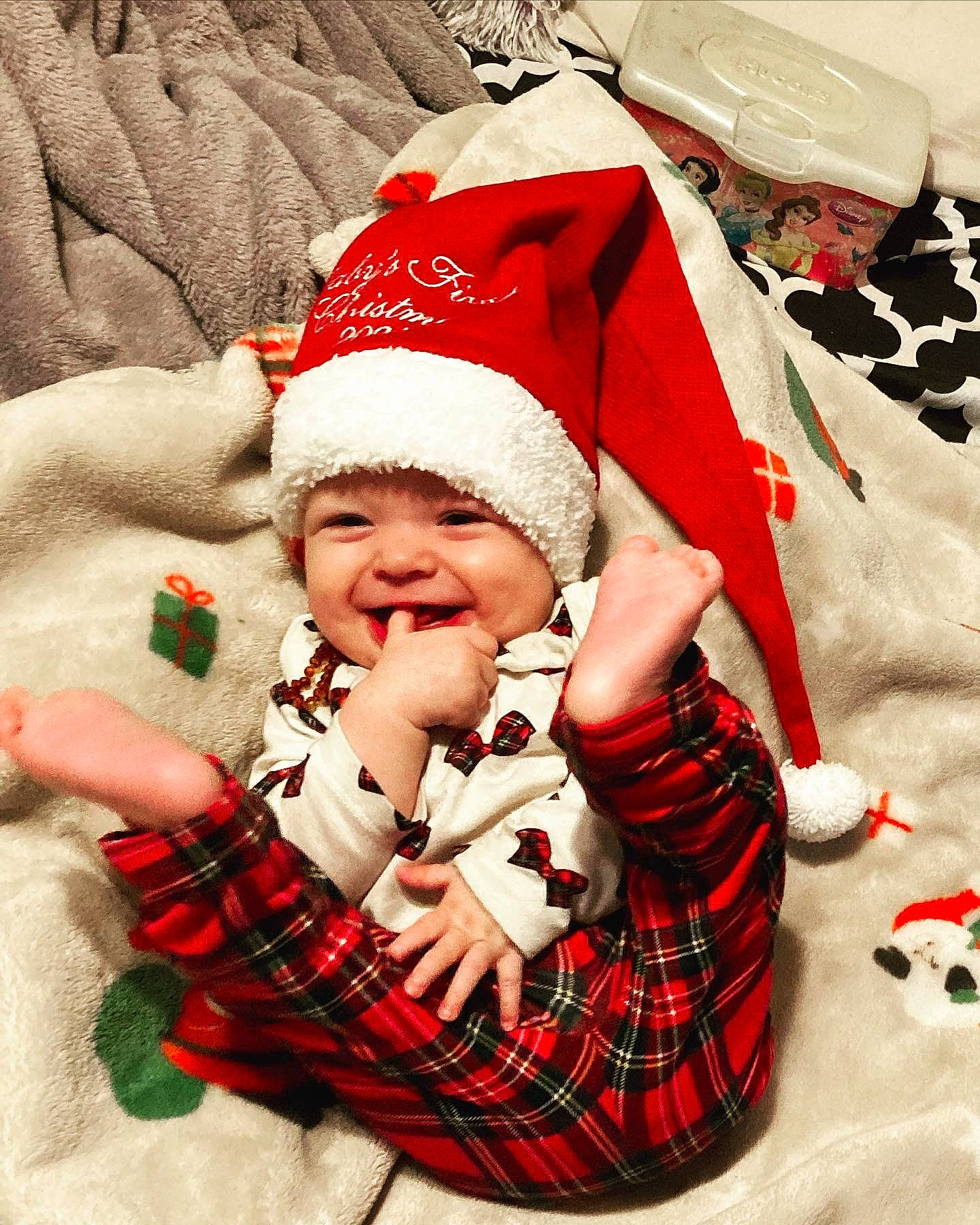 Ava Grace joined the competition — help win amazing prizes! baby, baby_toddler_clothing, cap, comfort, event, fun, gesture, happy, headwear, holiday, lap, pattern, person, plaid, red, santa_claus, sleeve, smile, tartan, textile
