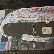 Happy joined the competition — help win amazing prizes! dog, blanket, black_dog, pet, cozy, indoor, animal, cute, fur, face, looking, snuggled, comfort, pattern, fabric, card, chip, technology, curious, portrait