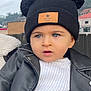 toddler, child, hat, beanie, pom_poms, blue_eyes, leather_jacket, white_sweater, outdoor, portrait, curious, fashion, clothing, winter_wear, baby, headwear, person, expression, cute, young_child
