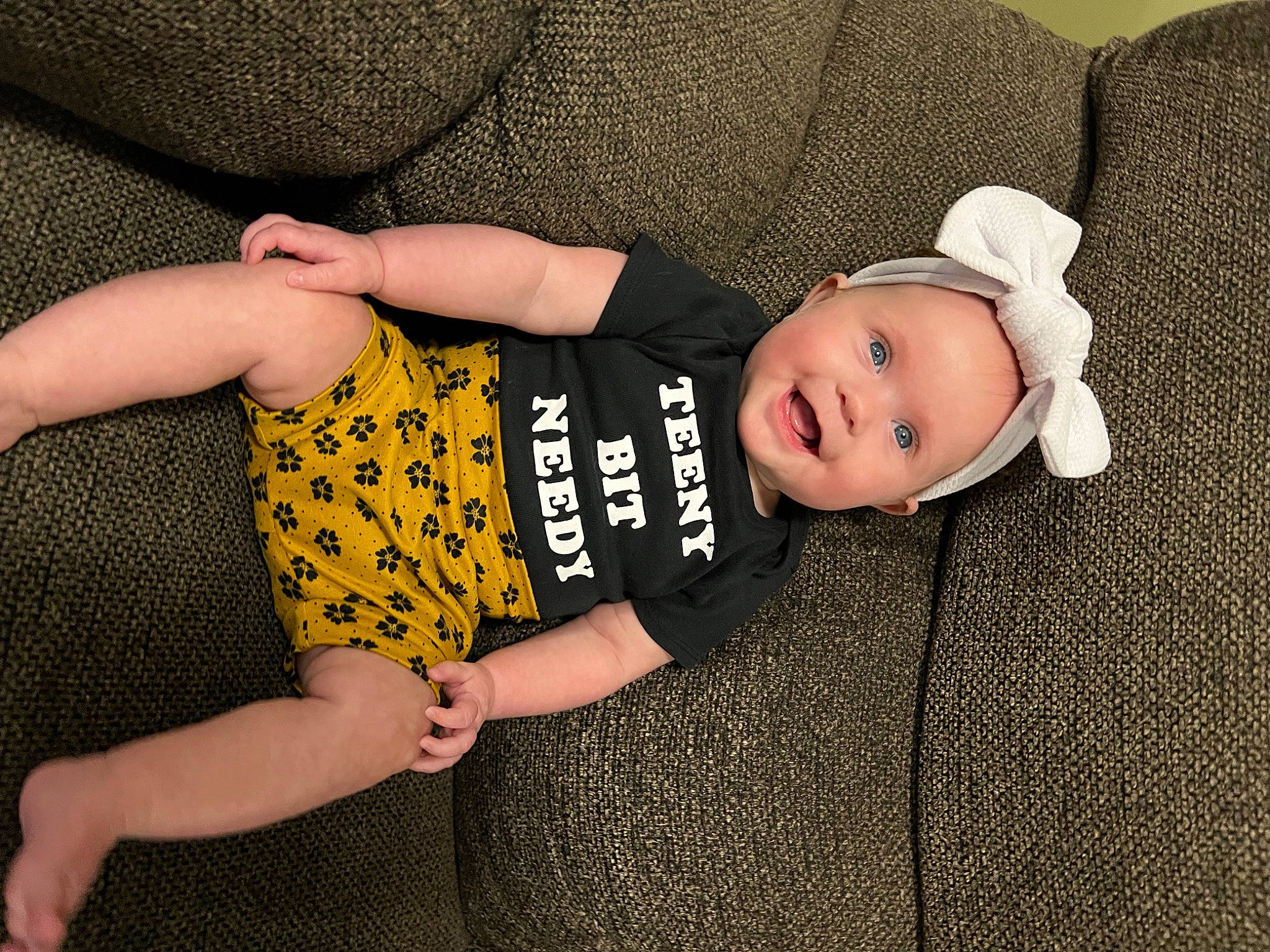 Ellie joined the competition — help win amazing prizes! baby, baby_products, baby_toddler_clothing, child, comfort, eye, finger, gesture, hand, hat, head, headgear, headwear, human_body, leg, pattern, person, sleeve, smile, sun_hat