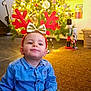 Livio participe au concours pour gagner de l'argent avec cette photo : child, toddler, reindeer_antlers, christmas_tree, holiday_lights, blue_shirt, green_pants, sock, indoor, carpet, toy, nutcracker, festive, holiday_decor, smiling, cute, cozy, home, celebration, seasonal