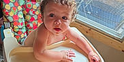 Tevy joined the competition — help win amazing prizes! baby, high_chair, food, indoor, curly_hair, window, tray, person, child, diced_food, wooden_frame, carpet, furniture, curious, looking_up, mouth_open, natural_light, colorful, cozy, home