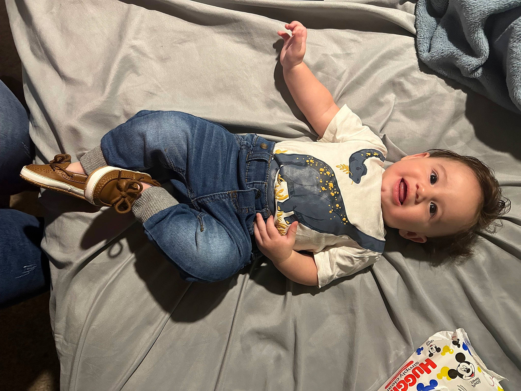 Edward is registered to the contest to win money with this photo: abdomen, baby_products, baby_toddler_clothing, bag, child, comfort, denim, elbow, face, fun, human, human_leg, knee, mammal, person, room, sitting, textile, thigh, toddler