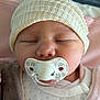 baby, pacifier, sleeping, hat, knitted_hat, blanket, clothing, face, infant, closeup, cute, newborn, soft, indoors, child, peaceful, resting, swaddled, warm, comfort