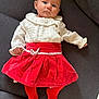 baby, infant, child, sofa, couch, red_skirt, white_blouse, red_tights, button, face, eyes, head, portrait, indoor, cozy, fabric_texture, hands, legs, laying, curious_expression