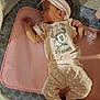 baby, sleeping, infant, headband, pink_clothing, polka_dot_pants, minnie_mouse, playpen, mat, cute, peaceful, child, small_hands, small_feet, patterned_padding, soft_lighting, indoors, resting, cozy, adorable