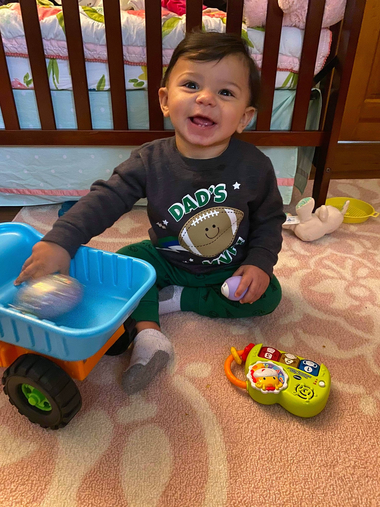 Chad is registered to the contest to win money with this photo: baby, child, fun, person, play, smile, toddler, toy, vehicle