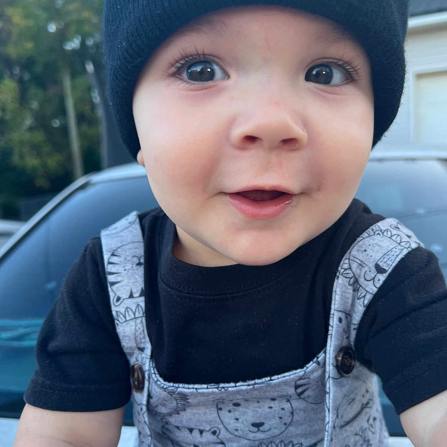 Ian is registered to the contest to win money with this photo: animal_print, baby, beanie, car, child, clothing, cute, expression, eyes, face, happy, hat, headwear, infant, outdoor, overalls, person, portrait, smile, young