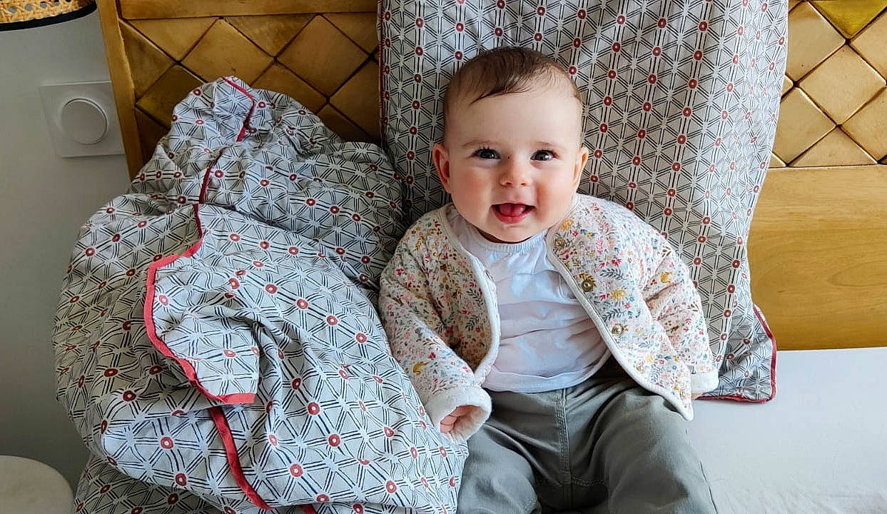 Héloïse a rejoint le concours — aidez-le/la à gagner de superbes lots ! baby, baby_toddler_clothing, chair, child, collar, comfort, couch, eye, fun, happy, linens, mammal, pattern, person, plaid, sitting, skin, sleeve, smile, textile