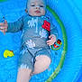 Ruben is registered to the contest to win money with this photo: baby, child, pool, inflatable_pool, water, swimsuit, turtle_pattern, toy_duck, toy_boat, blue, playful, tongue_out, sitting, summer, outdoor, cute, infant, floating_toys, water_play, relaxing