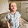 Stefan a rejoint le concours — aidez-le/la à gagner de superbes lots ! blue, boy, cabinet, carpet, child, construction_vehicle_print, cute, floor, indoor, jeans, kitchen, pants, pattern, person, playful, pout, shirt, standing, toddler, white