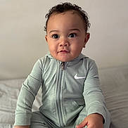 Leo joined the competition — help win amazing prizes! baby, child, infant, curly_hair, sitting, bed, clothing, nike, hoodie, foot, hand, wooden_sign, ten_months, portrait, cute, indoors, soft_light, expression, person, young