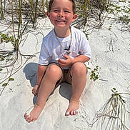 Grayson joined the competition — help win amazing prizes! child, boy, smiling, beach, sand, barefoot, grass, sunny, outdoor, casual_clothing, white_shirt, shorts, necklace, happy, young, summer, nature, recreation, sitting, vacation