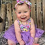 baby, child, smiling, purple_tutu, headband, outdoor, wooden_bench, brick_wall, cute, happy, sitting, foot, hand, patterned_cushion, toddler, clothing, headwear, face, person, infant