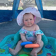 Gentry joined the competition — help win amazing prizes! baby, child, inflatable_pool, sun_hat, swimsuit, plastic_toys, beach, canopy, outdoor, summer, water_toy, tent, shade, person, sand, building, window, toy_rings, cute, play