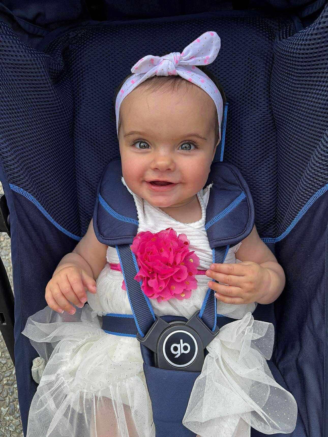 érina a rejoint le concours — aidez-le/la à gagner de superbes lots ! baby, child, smiling, stroller, headband, bow, flower, white_dress, happy, cute, infant, child_seat, blue, pink, tulle, portrait, outdoor, person, baby_clothing, seatbelt