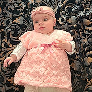 érina participe au concours pour gagner de l'argent avec cette photo : baby, infant, pink_dress, headband, knitted_clothing, white_tights, patterned_blanket, lying_down, cute, child, portrait, soft_lighting, indoors, adorable, young_child, fashion, baby_girl, textile, hand, face