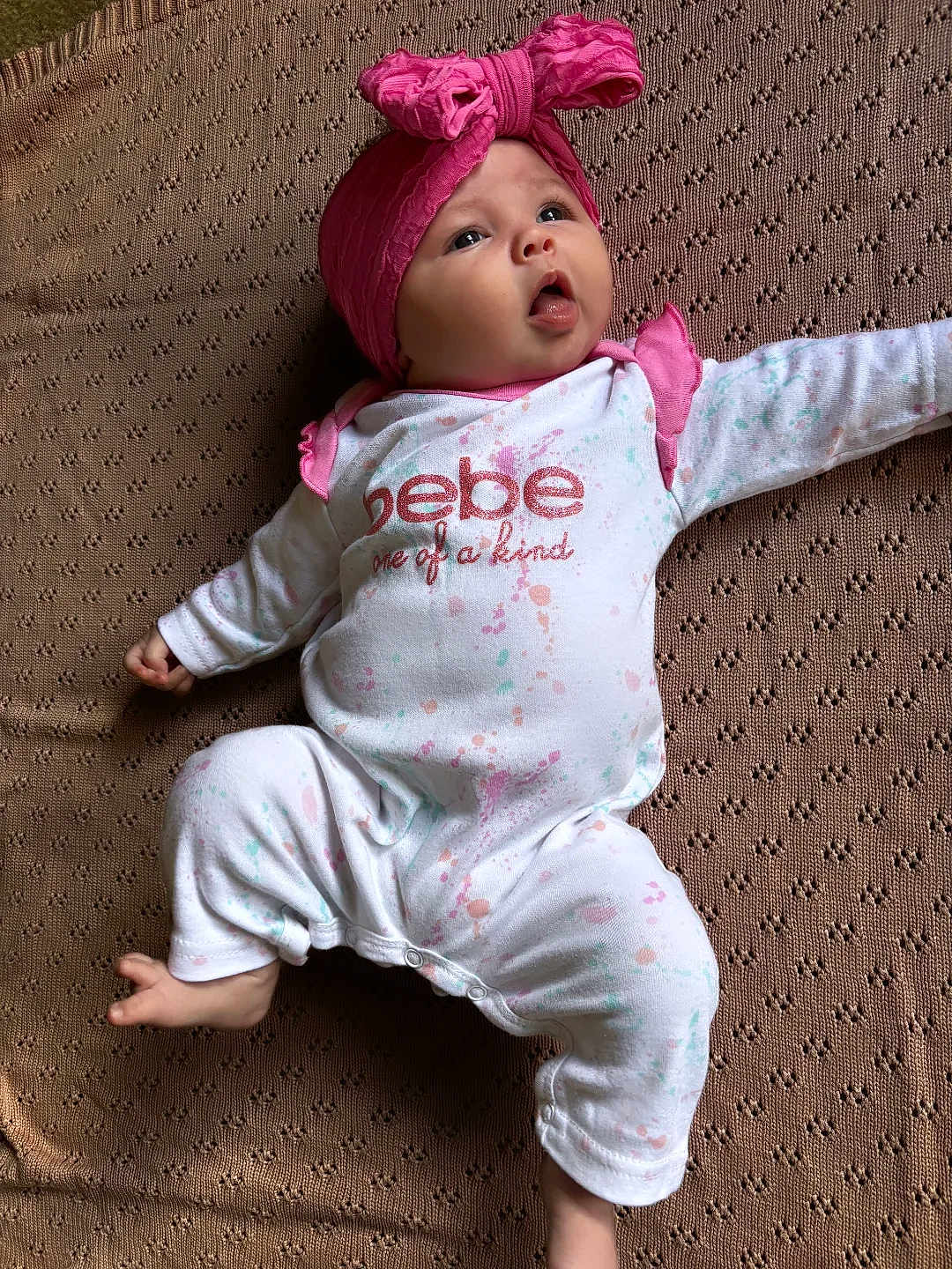 Delaney is registered to the contest to win money with this photo: baby, infant, child, headband, pink, onesie, clothing, lying_down, blanket, texture, looking_up, cute, soft_lighting, expression, small_hands, small_feet, home, indoors, portrait, peaceful