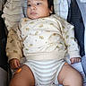 baby, infant, child, bassinet, blanket, clothing, sweatshirt, striped, cute, chubby, legs, hands, face, indoors, resting, looking_away, soft_lighting, fabric, comfort, toddler