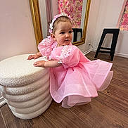 Mia participe au concours pour gagner de l'argent avec cette photo : child, toddler, baby, pink_dress, headband, sparkle, ottoman, mirror, floral_wall, boutique, wood_floor, stool, bracelet, portrait, curious, sitting, pretty, indoor, face, cheeks