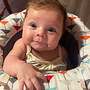 Rylin is registered to the contest to win money with this photo: baby, infant, child, smiling, face, eyes, hand, seat, patterned, clothing, cute, indoor, floor, wooden_floor, expression, closeup, young, person, happy, curious