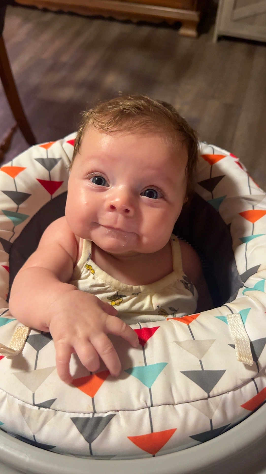 Rylin is registered to the contest to win money with this photo: baby, infant, child, smiling, face, eyes, hand, seat, patterned, clothing, cute, indoor, floor, wooden_floor, expression, closeup, young, person, happy, curious