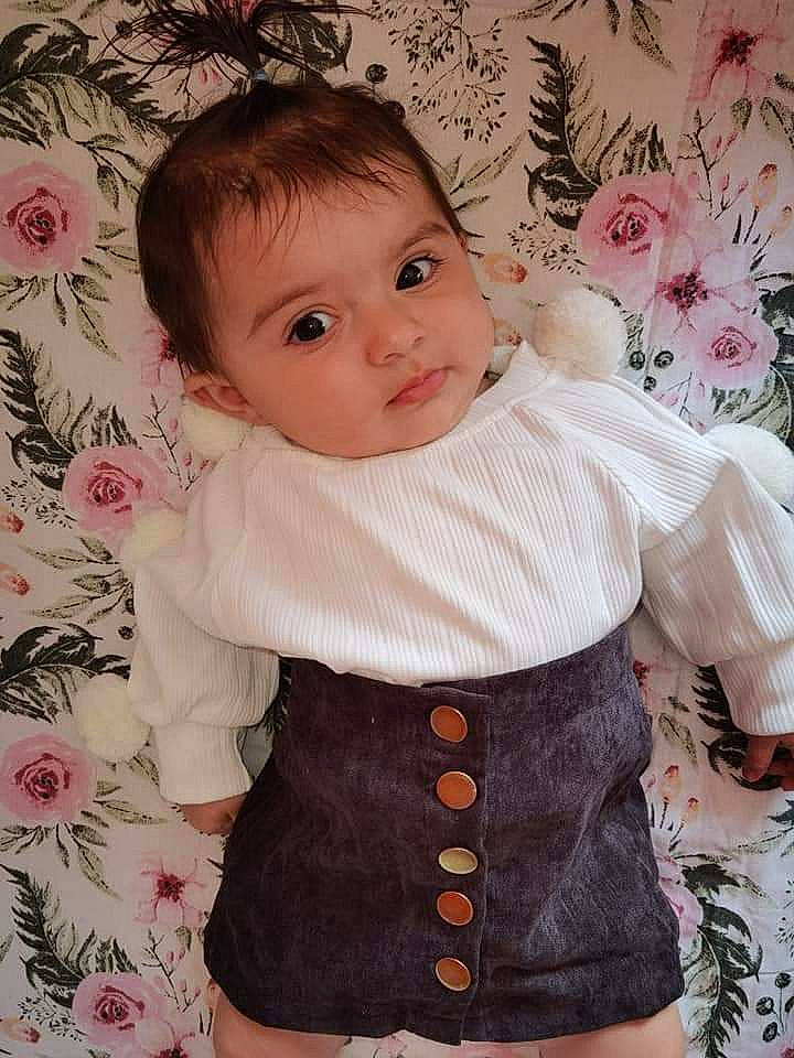 Stella is registered to the contest to win money with this photo: baby_toddler_clothing, cheek, creative_arts, dress, eye, face, facial_expression, hairstyle, head, iris, lip, organ, outerwear, person, pink, product, skin, sleeve, textile, toddler