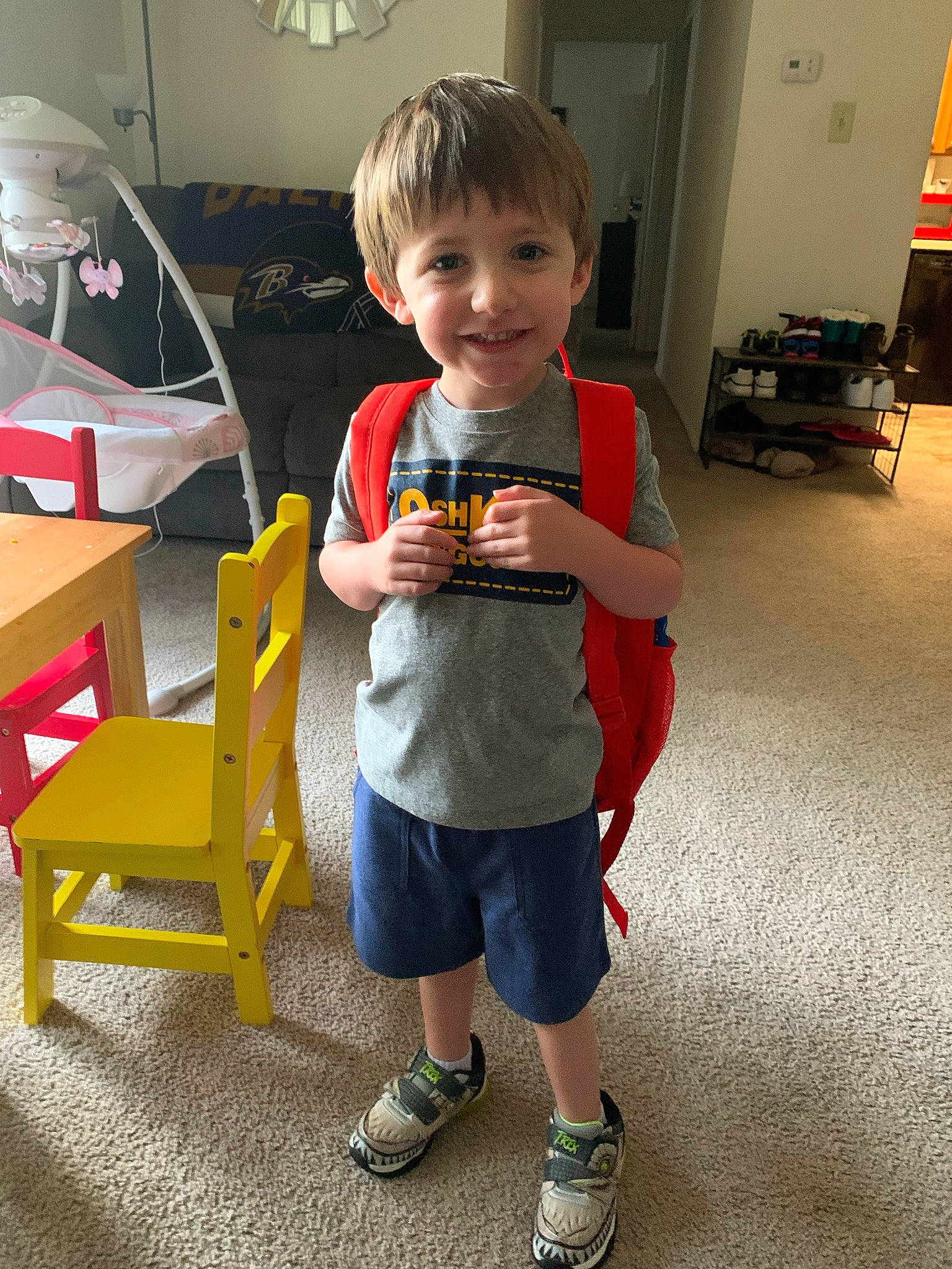 Emerson is registered to the contest to win money with this photo: aircraft, chair, child, floor, flooring, fun, joy, leisure, person, play, room, shoe, shorts, sitting, smile, sneakers, standing, t_shirt, table, thumb