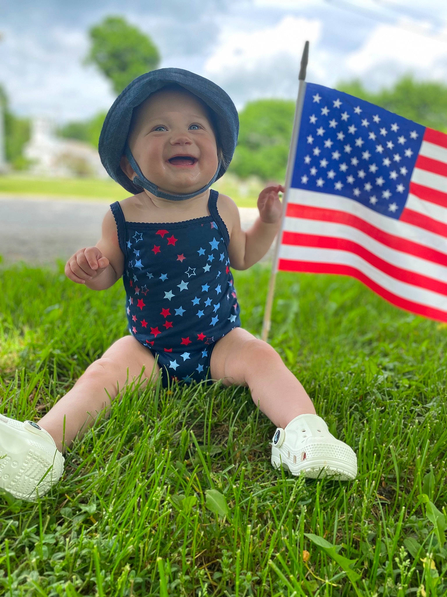 Rylynn joined the competition — help win amazing prizes! baby, baby_toddler_clothing, cloud, electric_blue, flag, flag_of_the_united_states, grass, grassland, happy, hat, headwear, leisure, meadow, people_in_nature, person, plant, sky, smile, summer, t_shirt