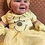 Ruby is registered to the contest to win money with this photo: baby, child, smile, yellow_clothing, mittens, tulle_skirt, hat, face, portrait, happy, infant, cute, seated, patterned_background, apparel, person, indoors, closeup, soft_lighting, adorable