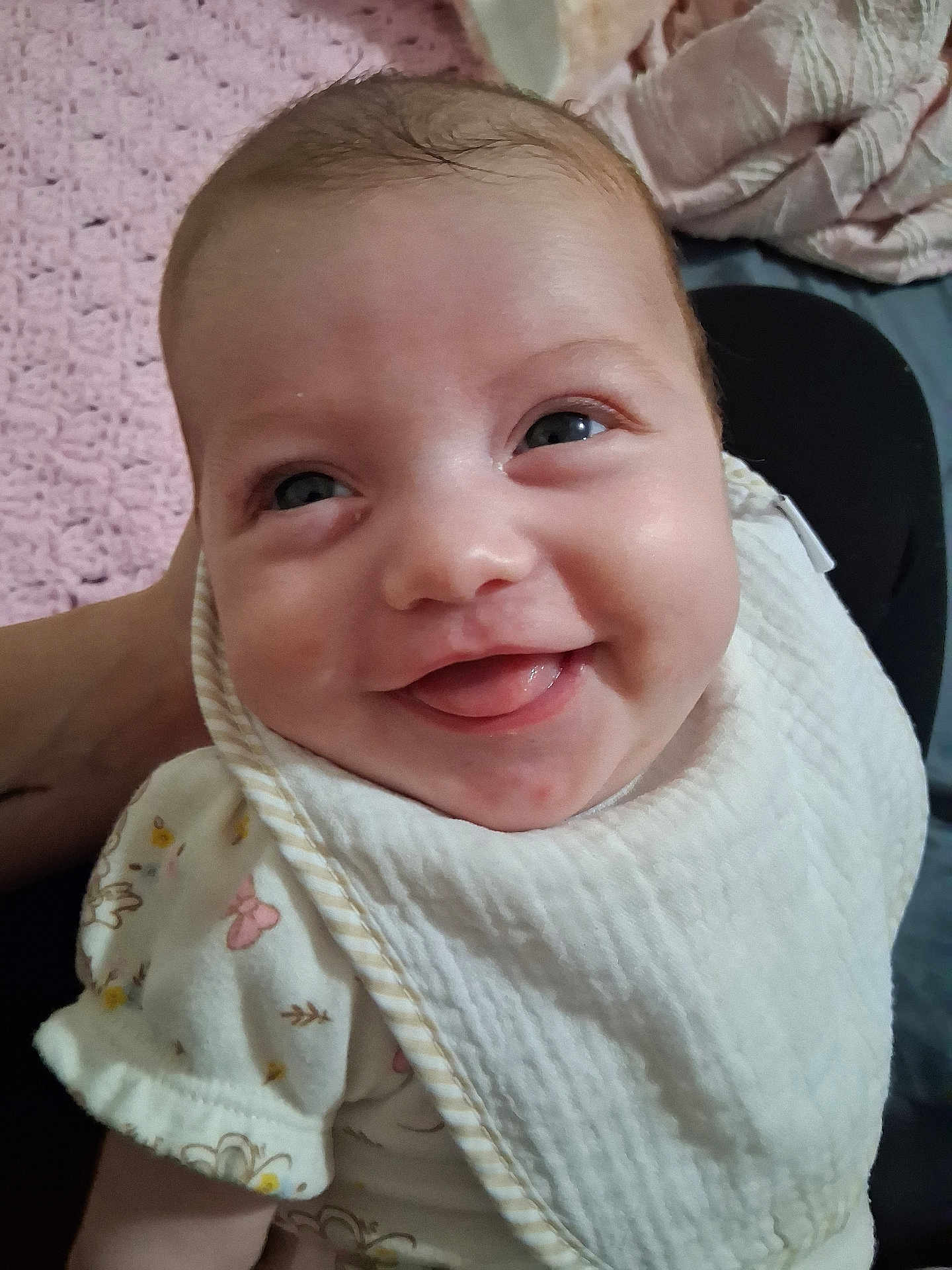 Vivian joined the competition — help win amazing prizes! baby, smile, face, infant, bib, clothing, tongue, close_up, person, cute, happy, indoors, child, soft_texture, fabric, blanket, patterned_clothing, head, skin, young