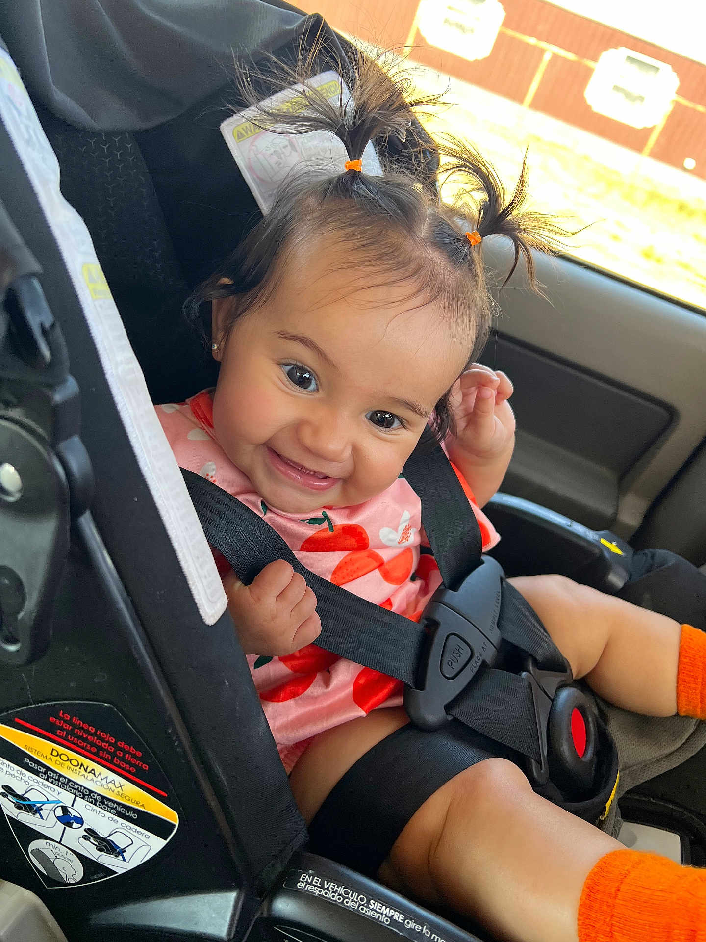 Anna Liz Falcon is registered to the contest to win money with this photo: baby, car_interior, car_seat, cherry_pattern, child, cute, hair_ties, happy, infant, orange_socks, pink_clothing, playful, pony_tails, portrait, safety_harness, seatbelt, secured, sitting, smiling, young_child