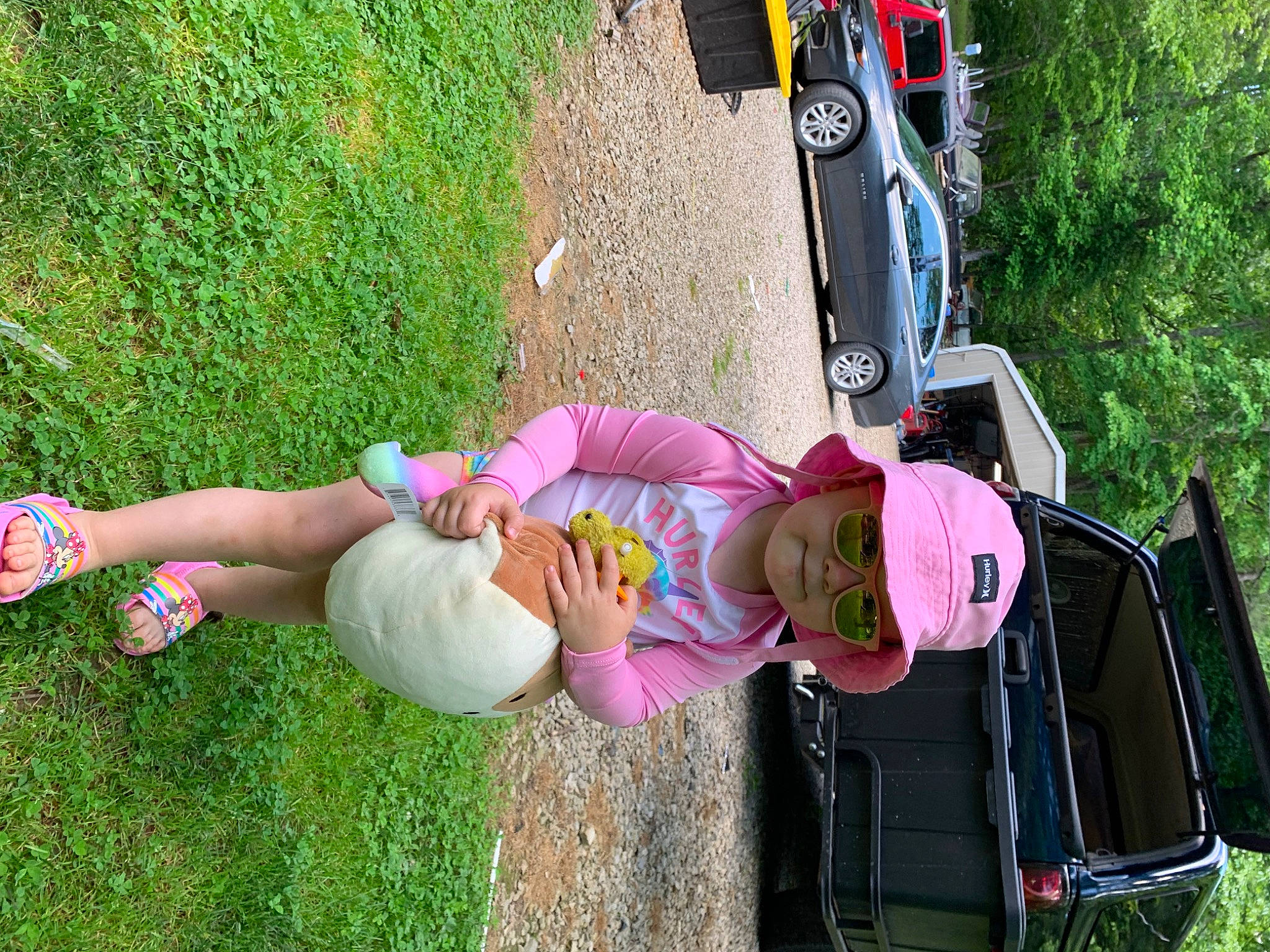 Clara is registered to the contest to win money with this photo: automotive_exterior, automotive_lighting, automotive_tire, car, family_car, fun, grass, green, headwear, land_vehicle, lawn, leisure, motor_vehicle, person, pink, plant, recreation, tire, tree, vehicle