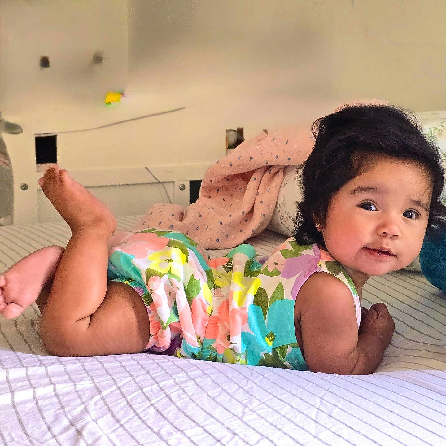 Nayanci joined the competition — help win amazing prizes! baby, child, infant, portrait, smiling, happy, lying_down, bed, bedroom, floral_outfit, colorful_clothing, barefoot, raised_foot, pillow, blanket, bedding, indoors, home, cute, photography