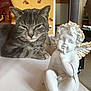 animal, cat, cherub, cozy, decor, ears, eyes, face, furniture, gray, home, indoor, paws, pet, relaxing, sculpture, statue, tabby, table, whiskers