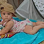 baby, child, towel, hat, outdoor, tent, grass, blanket, infant, clothing, person, face, headwear, skin, feet, nature, summer, lying_down, expression, daylight