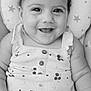 baby, child, smiling, face, portrait, infant, cute, happy, clothing, pattern, stars, cushion, close_up, skin, eyes, hair, sitting, button, monochrome, texture
